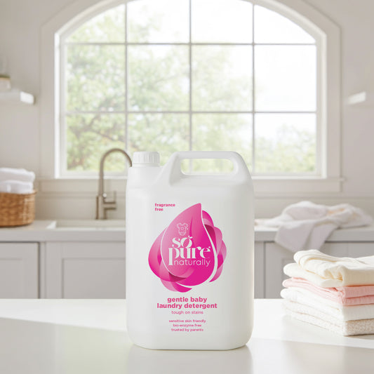 Pure Naturally gentle baby laundry detergent bottle on a kitchen counter with a window in the background